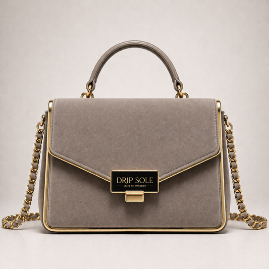 Gray handbag with gold chain and handle on a light gray background